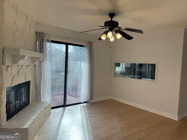 a view of an empty room with a fireplace and a window
