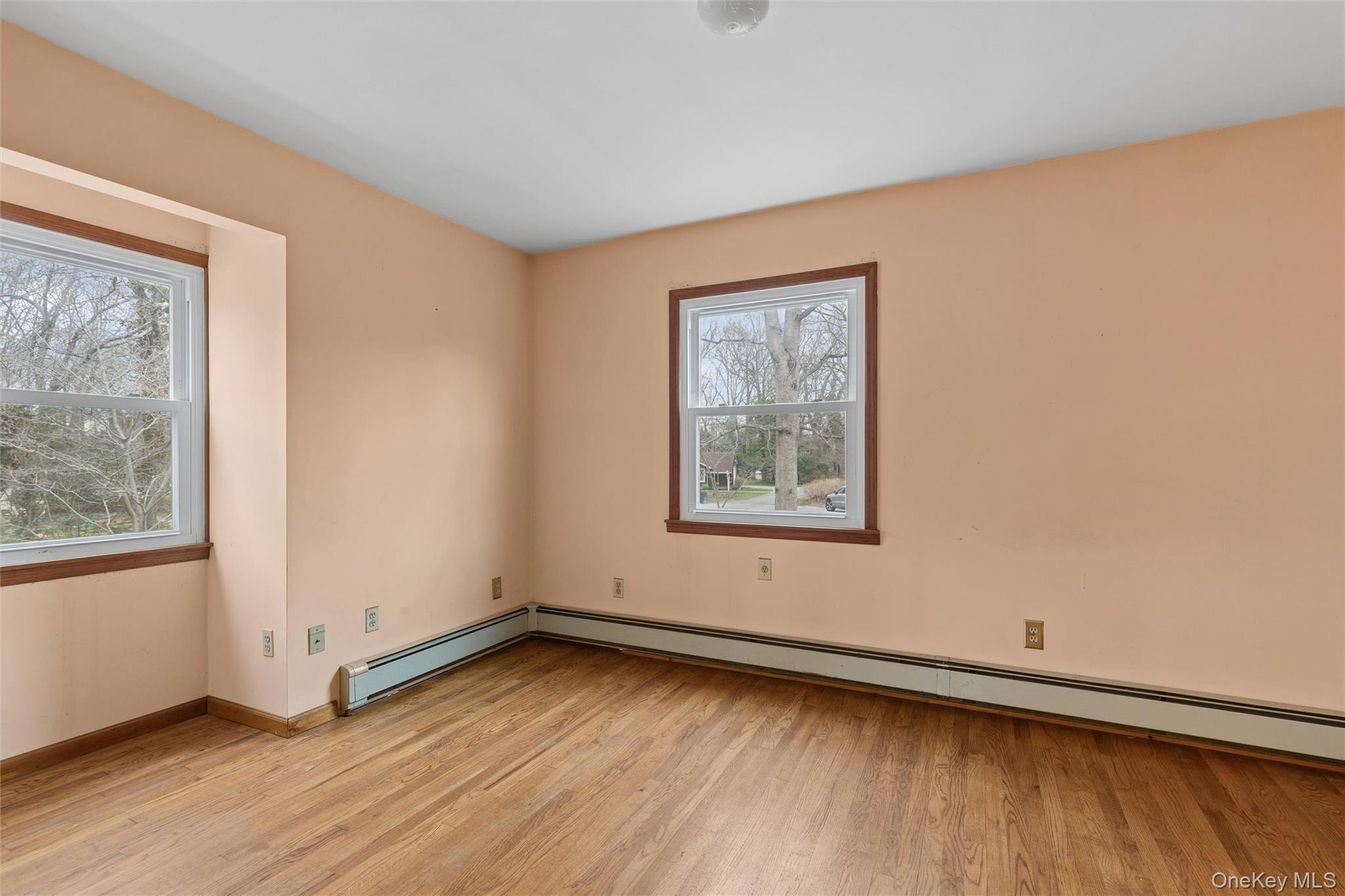 49 Overhill Road Wading River, NY 11792 - Photo 20 of 27 an empty room with wooden floor and windows