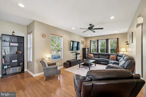 a living room with furniture ceiling fan and a window