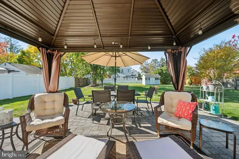 a view of chairs and table in patio with a small yard