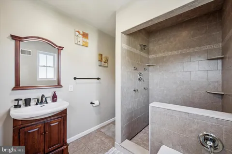 a bathroom with a sink a mirror and shower