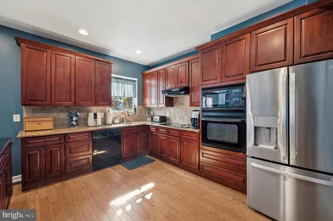 a kitchen with stainless steel appliances granite countertop a refrigerator stove top oven and sink