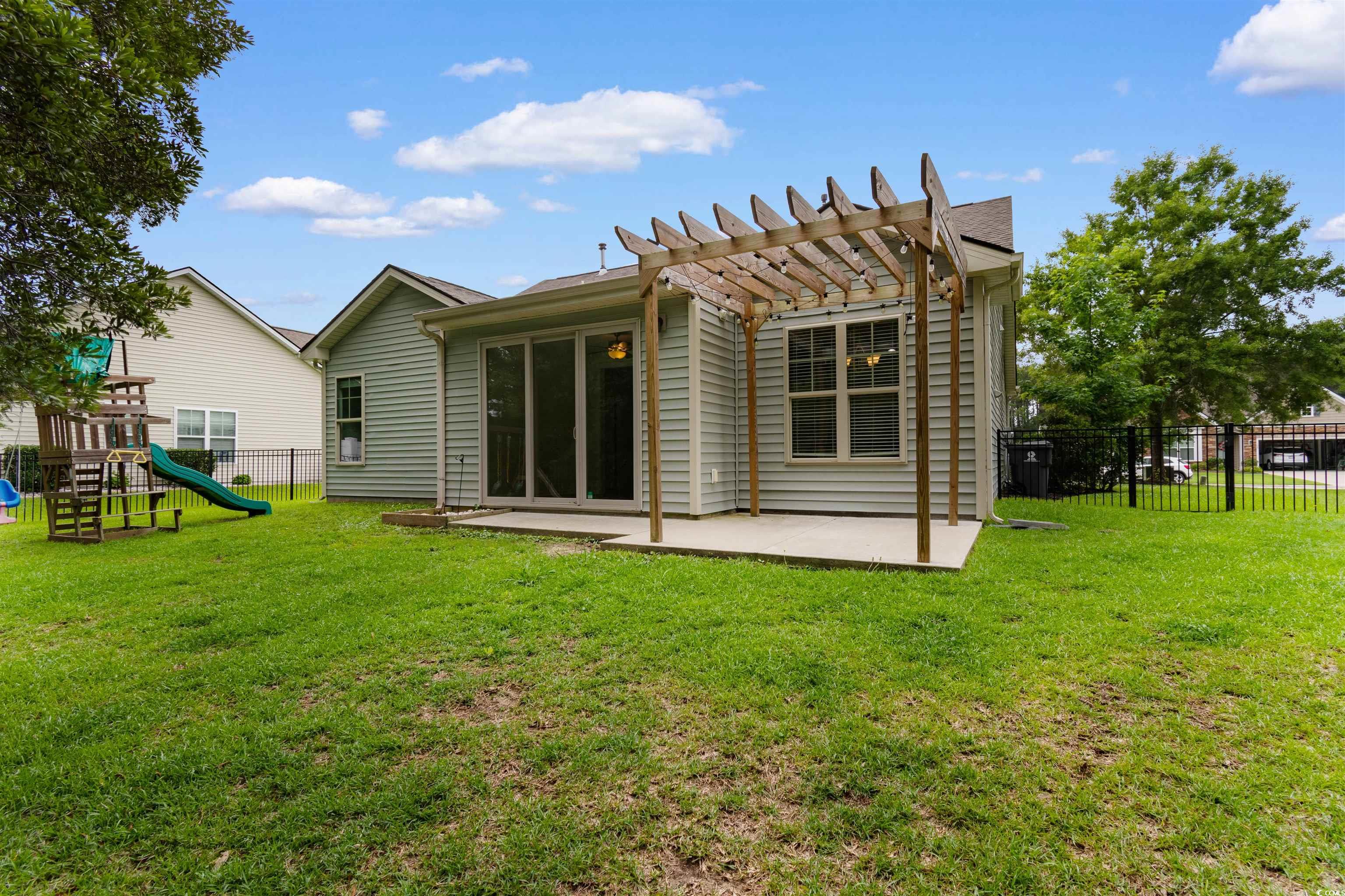 124 Shady Arbor Loop Longs, SC 29568 - Photo 27 of 40 Rear view of house featuring a pergola, a playground, and a patio area