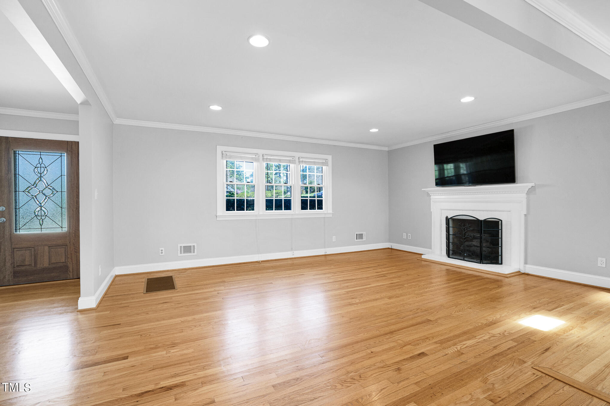 4501 Boxwood Road Raleigh, NC 27612 - Photo 15 of 44 a view of empty room with wooden floor and fireplace