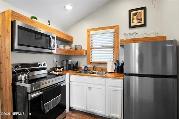 a kitchen with sink refrigerator and cabinets