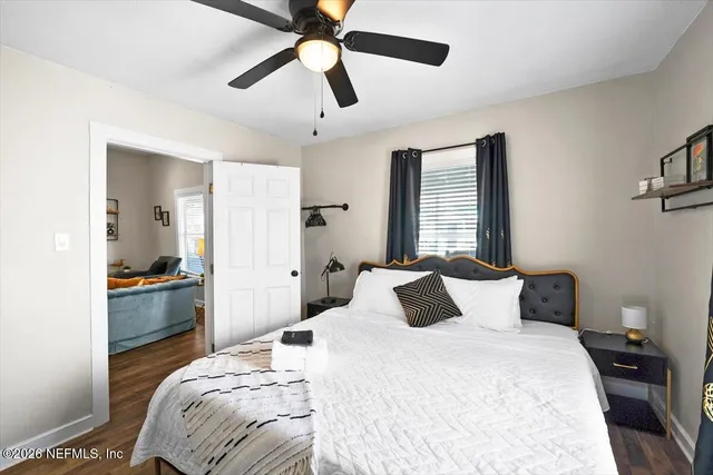 a bedroom with a bed a large window and flat screen tv