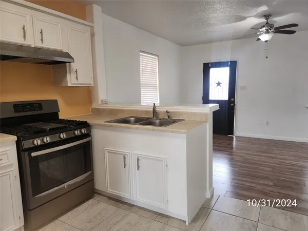 a kitchen with granite countertop a stove and a sink