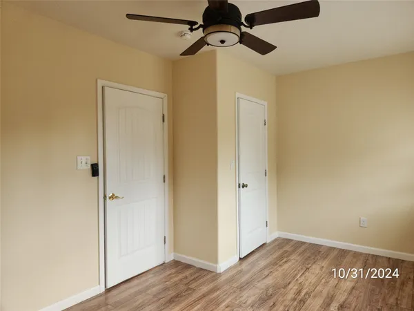 a view of a room with wooden floor closet and windows