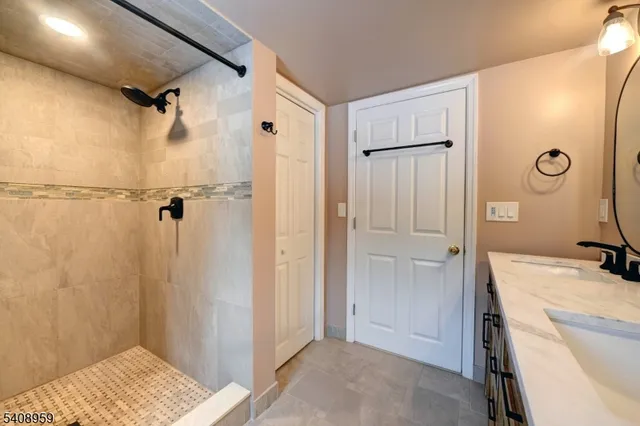 a bathroom with a granite countertop sink and shower