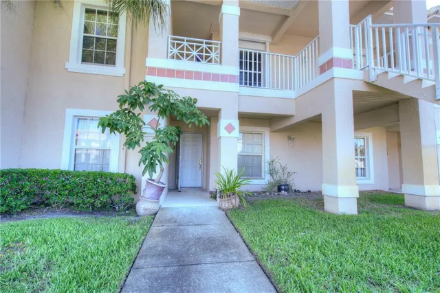 a front view of a house with a yard and potted plants