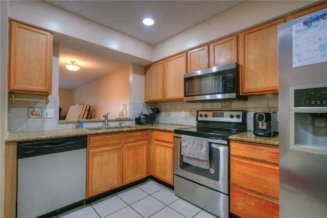 a kitchen with stainless steel appliances granite countertop a sink and stove top oven