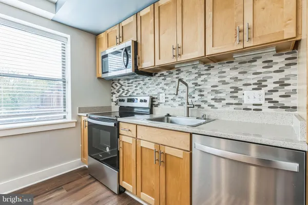 a kitchen with stainless steel appliances granite countertop a sink a stove and a microwave