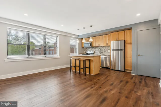 a kitchen with stainless steel appliances wooden floors and refrigerator