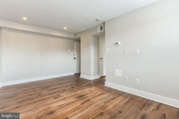 a view of an empty room with wooden floor