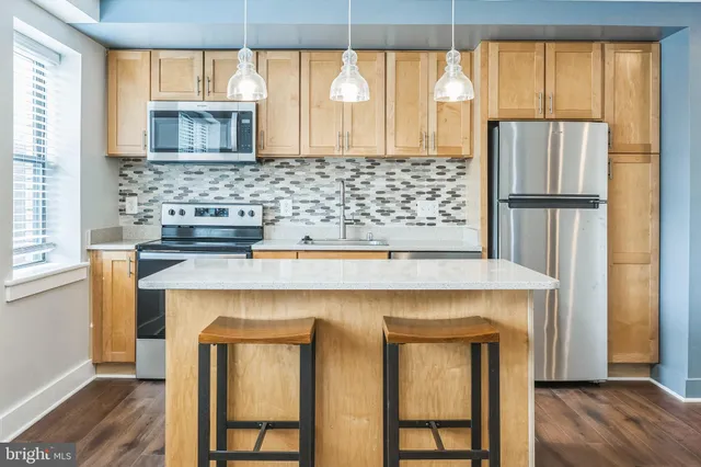 a kitchen with a refrigerator a sink and wooden cabinets