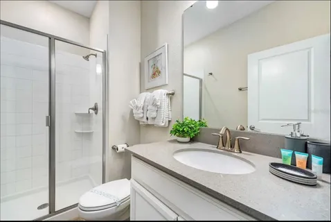 a bathroom with a granite countertop sink toilet and shower
