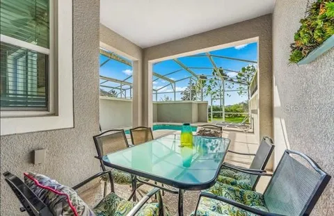 a view of a dining room with furniture a rug and wooden floor