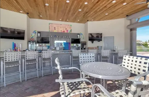 a kitchen with stainless steel appliances kitchen island granite countertop a table chairs sink and cabinets