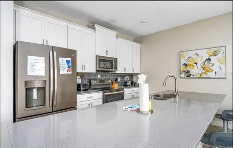 a kitchen with stainless steel appliances granite countertop a refrigerator a stove top oven a sink and dishwasher