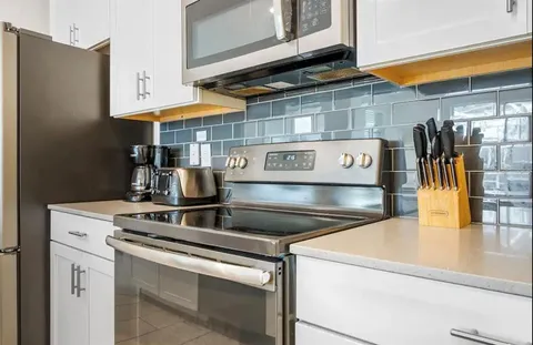 a kitchen with stainless steel appliances granite countertop a sink and a stove