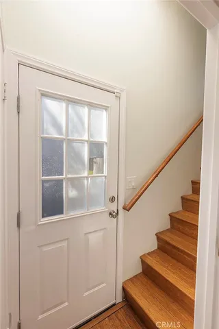 a view of staircase with wooden floor and white walls