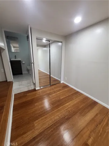an empty room with wooden floor and staircase