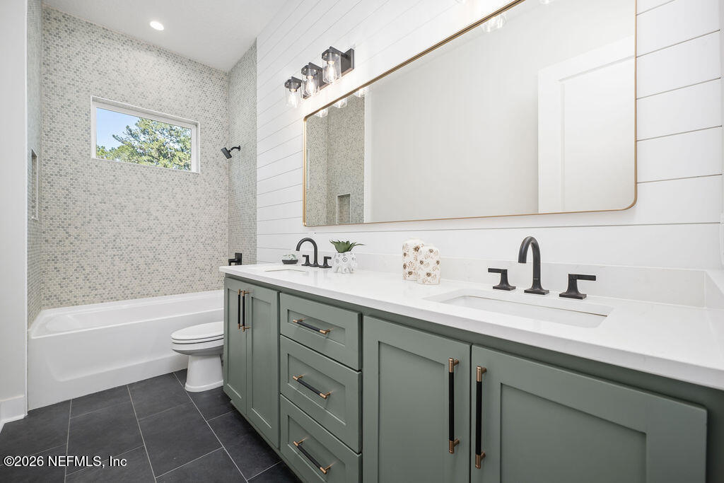 2747 Anchor Road Middleburg, FL 32068 - Photo 17 of 26 a bathroom with a granite countertop sink a toilet and a bathtub
