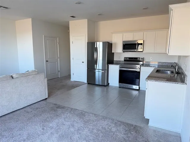 a kitchen with stainless steel appliances a refrigerator a stove a microwave and cabinets