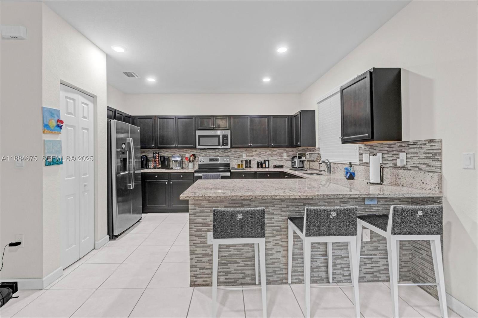 a kitchen with stainless steel appliances granite countertop a stove a sink a refrigerator and a oven