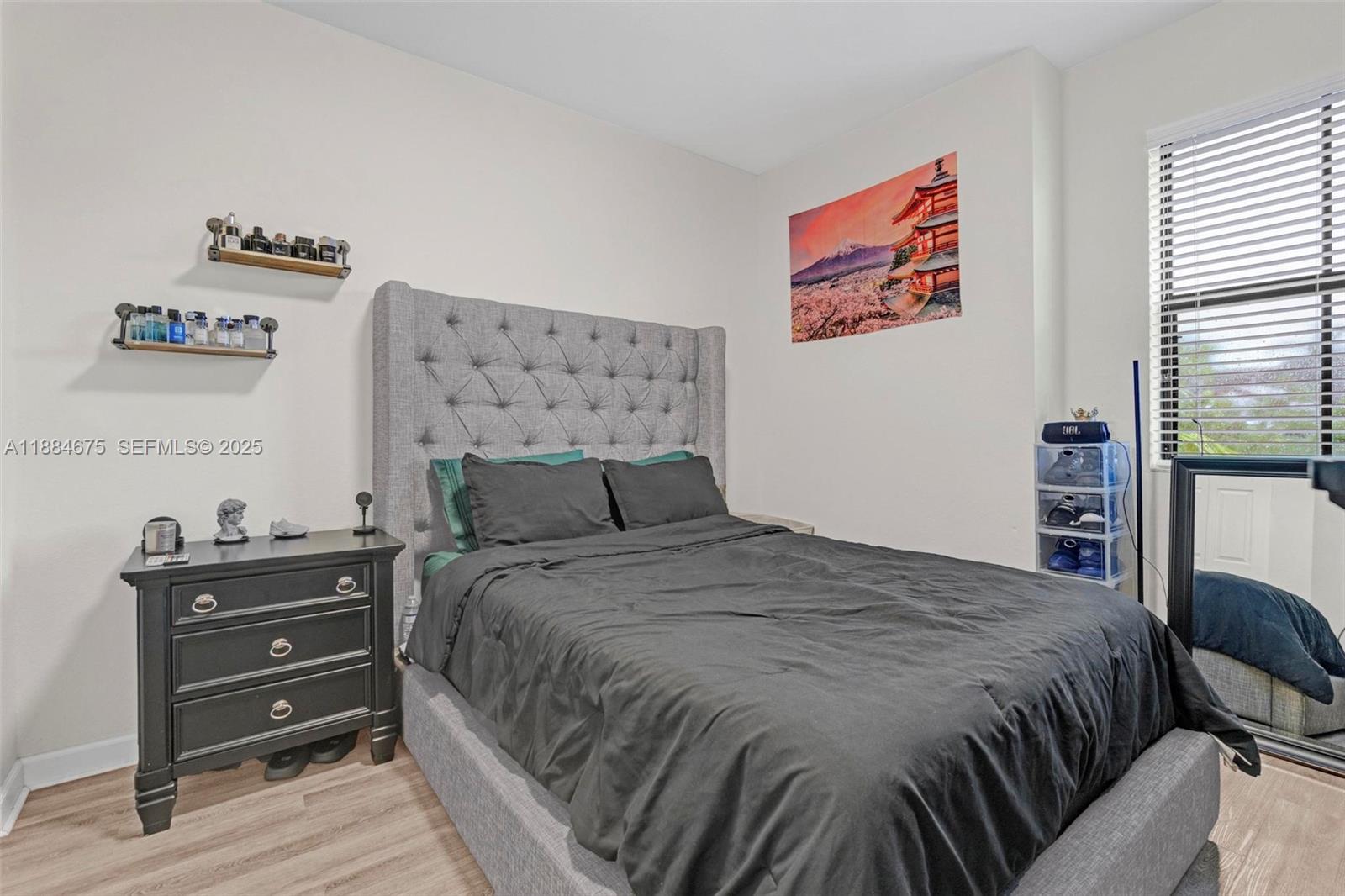 11413 Southwest 253rd Street, Unit 11413 Homestead, FL 33032 - Photo 18 of 44 a bedroom with a bed and dresser with wooden floor