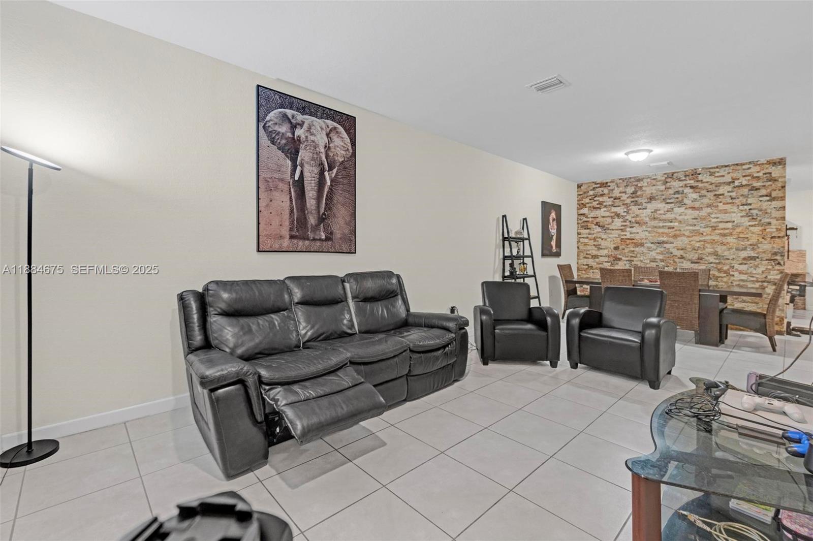 11413 Southwest 253rd Street, Unit 11413 Homestead, FL 33032 - Photo 20 of 44 a living room with furniture a fireplace and a table