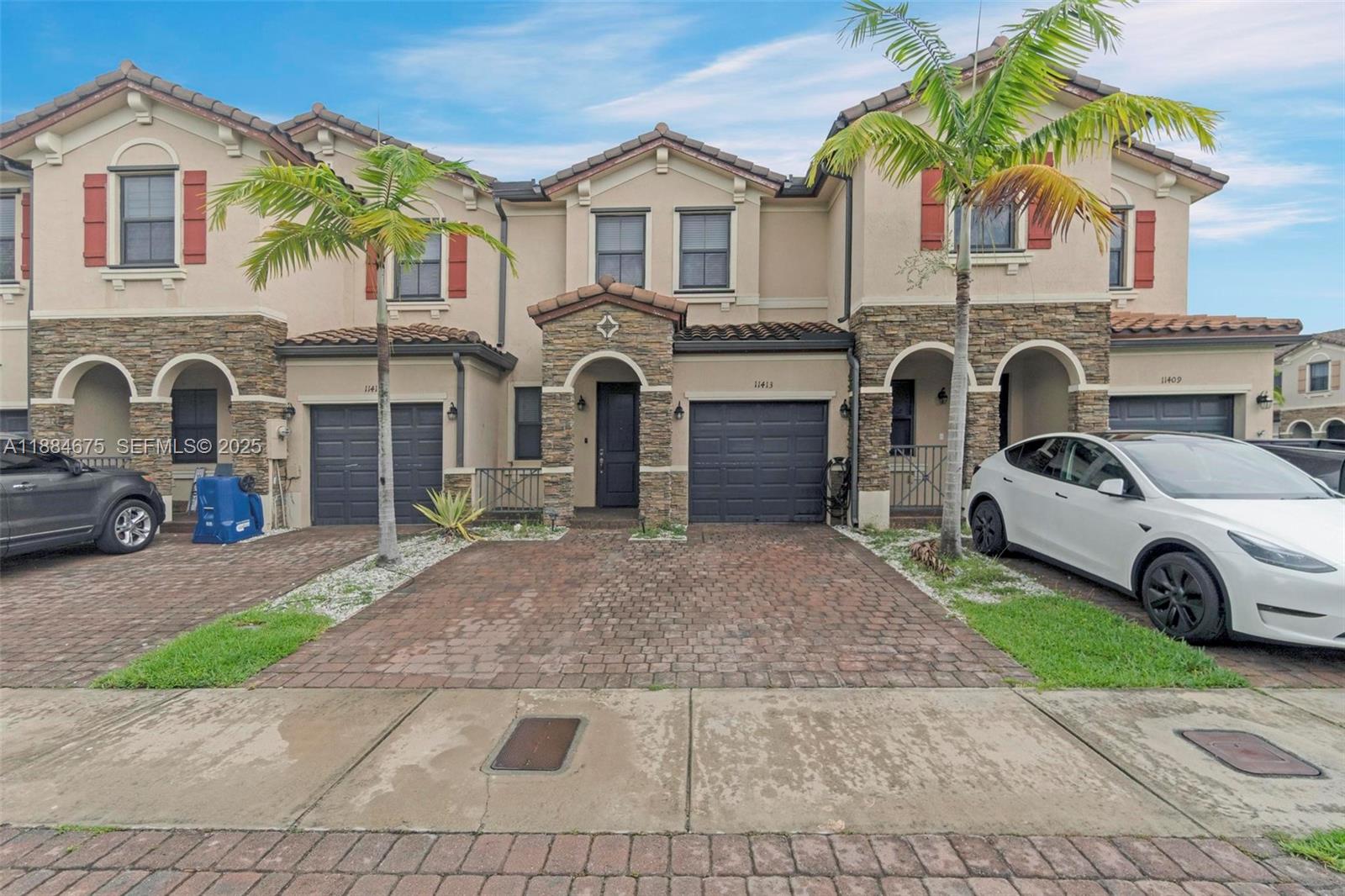 11413 Southwest 253rd Street, Unit 11413 Homestead, FL 33032 - Photo 2 of 44 a front view of a house with a garden and parking space