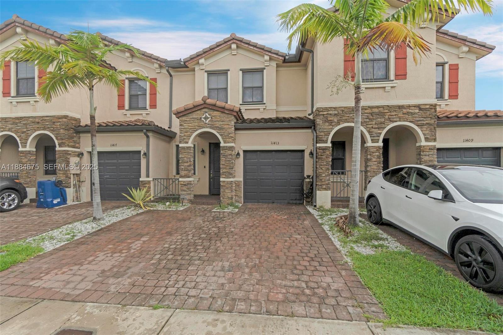 11413 Southwest 253rd Street, Unit 11413 Homestead, FL 33032 - Photo 4 of 44 a front view of a house with garden