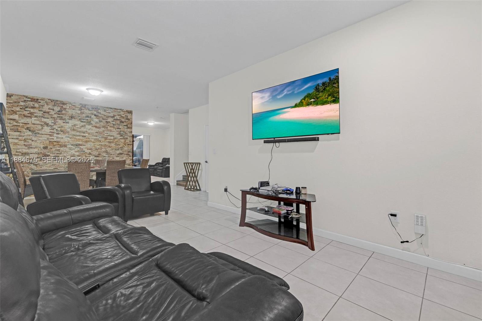 11413 Southwest 253rd Street, Unit 11413 Homestead, FL 33032 - Photo 43 of 44 a living room with furniture and a flat screen tv