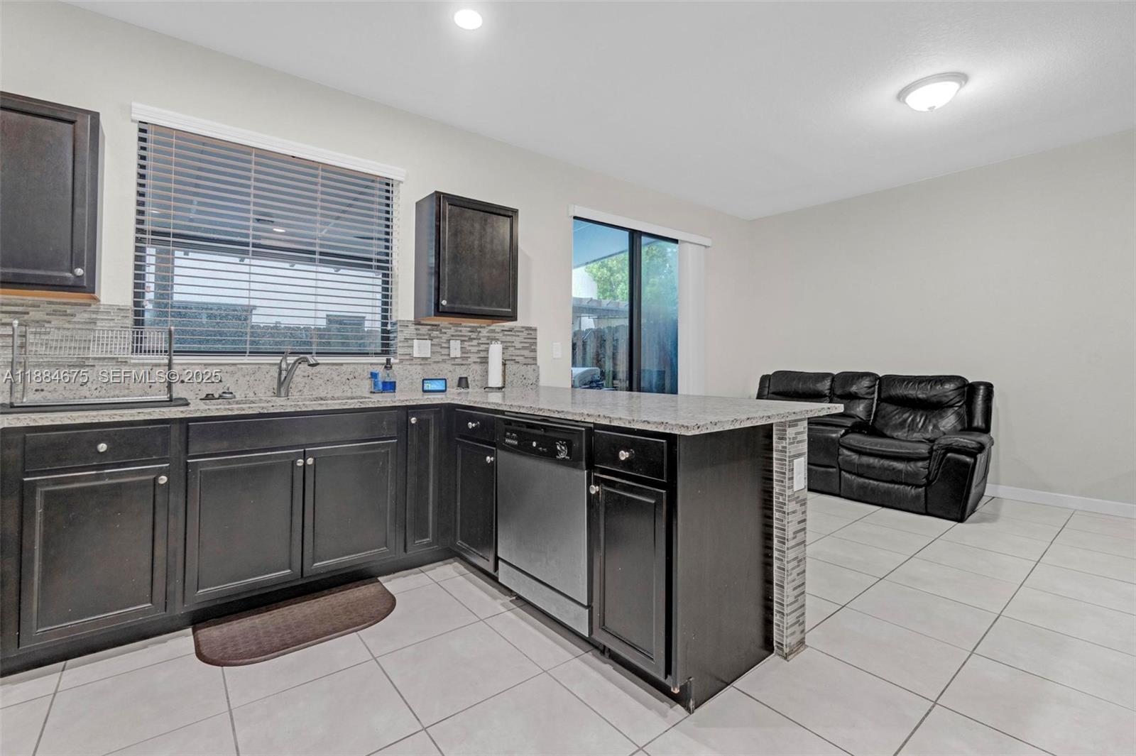 11413 Southwest 253rd Street, Unit 11413 Homestead, FL 33032 - Photo 8 of 44 a kitchen with stainless steel appliances granite countertop a sink and cabinets