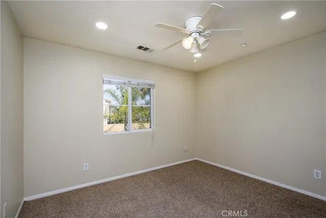 an empty room with a ceiling fan and a fan