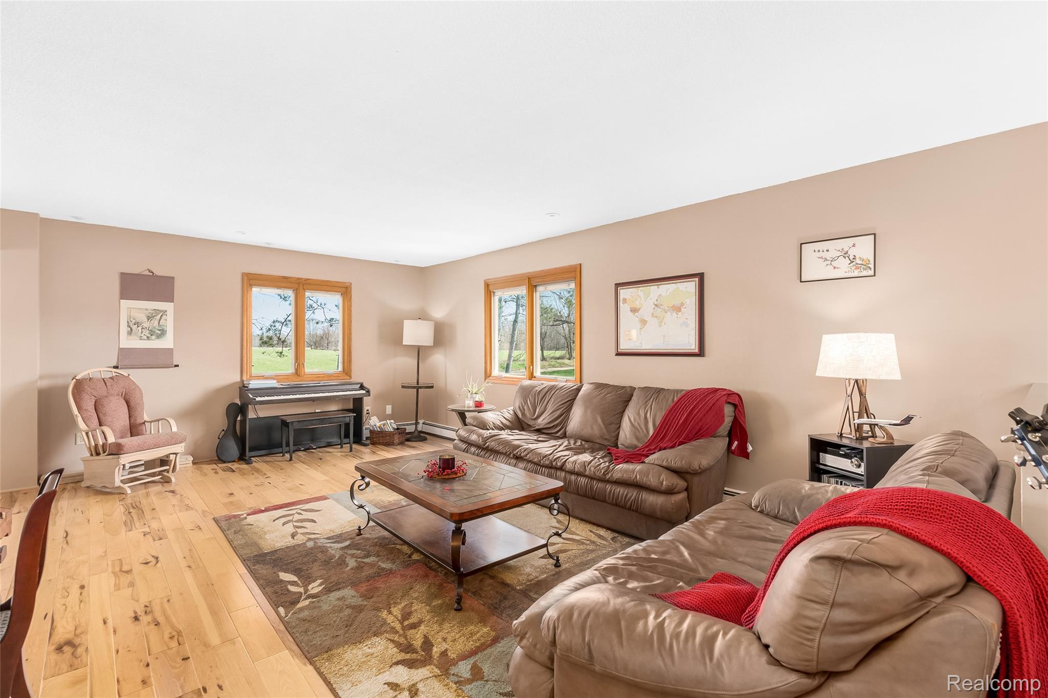 15395 Osius Road Chelsea, MI 48118 - Photo 4 of 55 Spacious room featuring light wood-finish flooring, two large windows with natural wood trim, and neutral-toned walls