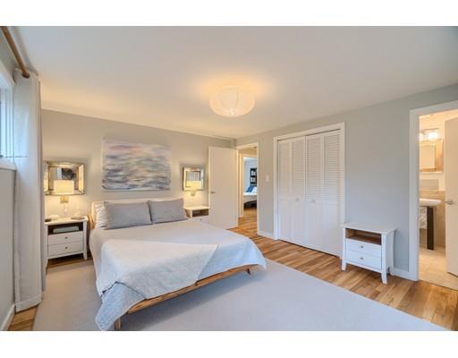 247 Sandy Pond Road Concord, MA 01773 - Photo 12 of 20 a bedroom with a large bed and a chandelier