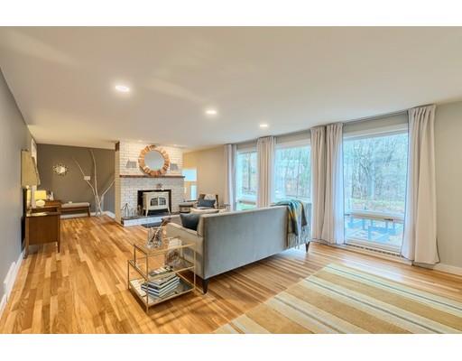 247 Sandy Pond Road Concord, MA 01773 - Photo 6 of 20 a living room with furniture a fireplace and a floor to ceiling window