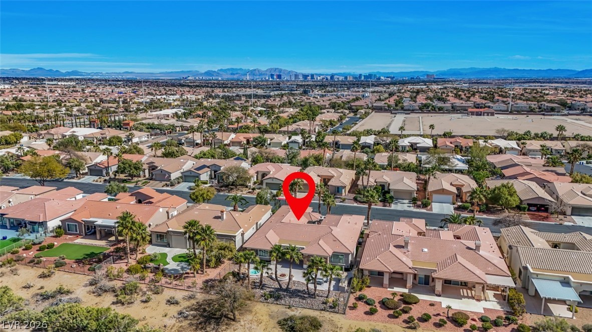 5015 Rivedro Street Las Vegas, NV 89135 - Photo 85 of 91 An aerial panorama reveals a vast suburban landscape, stretching towards distant mountains and a city skyline.