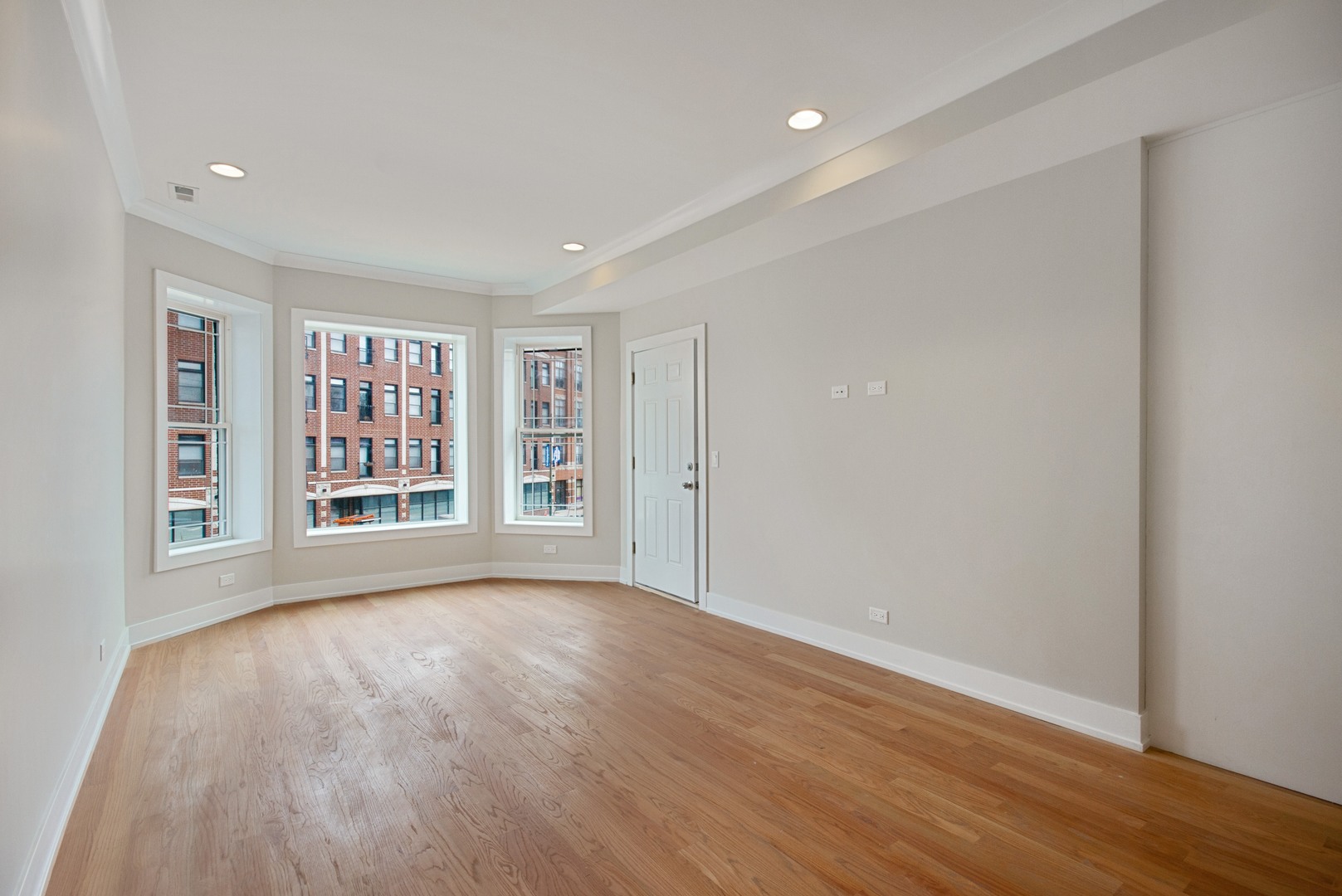 3750 North Racine Avenue, Unit 2 Chicago, IL 60613 - Photo 2 of 10 a view of an empty room with a window and wooden floor