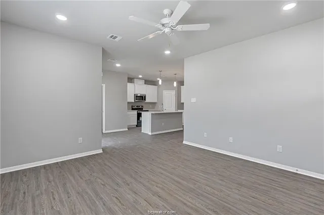 wooden floor in an empty room with a kitchen