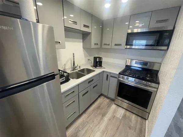 a kitchen with stainless steel appliances a refrigerator sink and stove