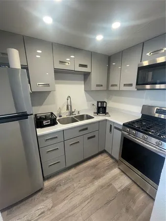 a kitchen with stainless steel appliances granite countertop a stove a sink and a refrigerator