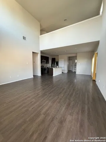 a view of empty room with wooden floor