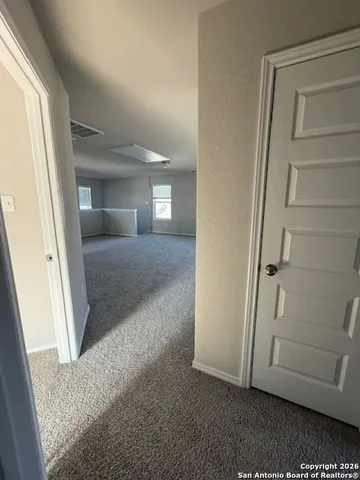 view of a hallway with closet and wooden floor
