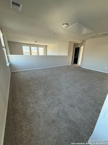 a view of an empty room with window and fireplace