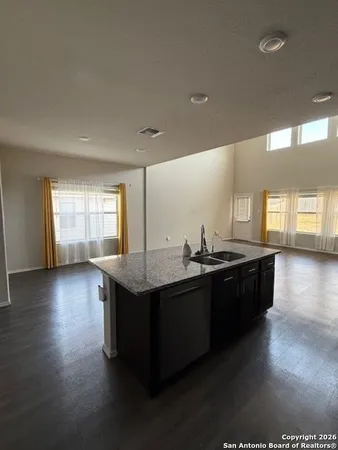 a kitchen with stainless steel appliances granite countertop a sink counter space and wooden floor