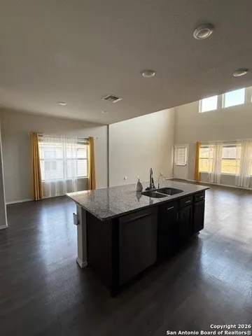 a kitchen with stainless steel appliances granite countertop a sink counter space and wooden floor