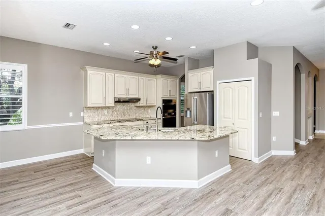 a kitchen with stainless steel appliances granite countertop a sink and refrigerator